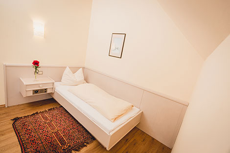 Gemütliches Einbettzimmer mit Bett und Nachtkasterl im Landgasthof Gietl